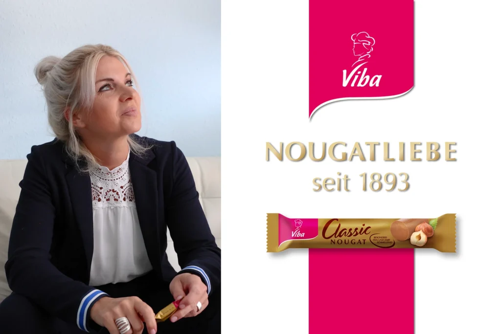 Thumbnail Nougat-Werbespot: Frau, die freudig Nougat in der Hand hält, rechts pinkes Viba-Logo, goldener Slogan "Nougatliebe seit 1893" und Nougatstange